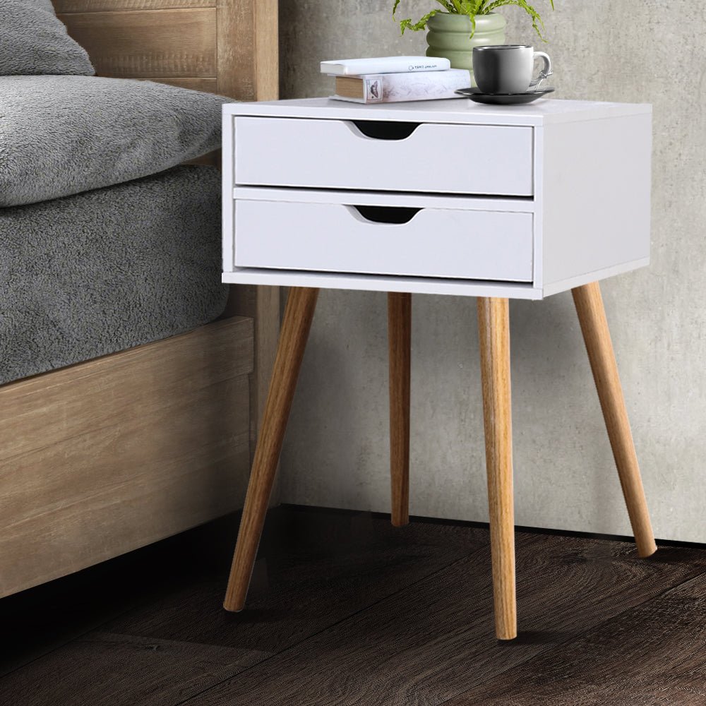 White wood bedside table with drawers for kids bedroom storage and decor. White wood bedside table with drawers for kids bedroom storage and decor.