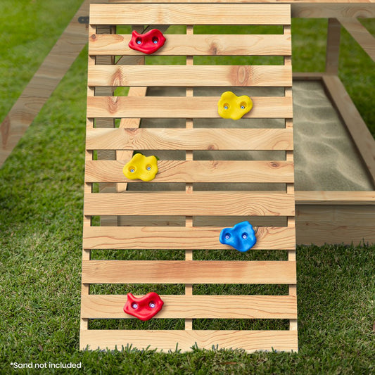 Childrens outdoor playhouse with slide, rock wall, and noughts and crosses board.