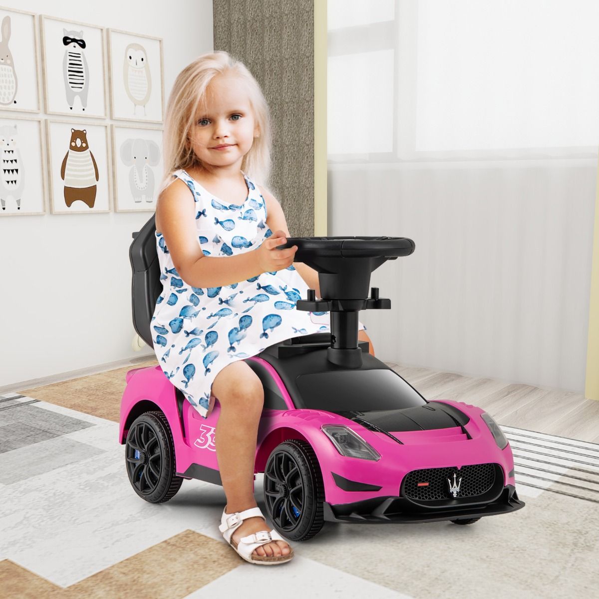 Pink Maserati-style ride-on car with musical steering wheel for interactive playtime and stylish cruising.