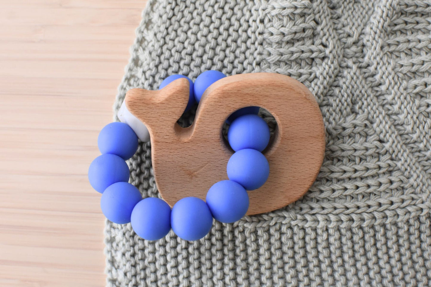 Wooden silicone whale teether in blue for babies, a soothing toy for teething relief.