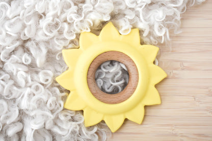 Yellow sunflower silicone teether for infants, promoting relief during teething.