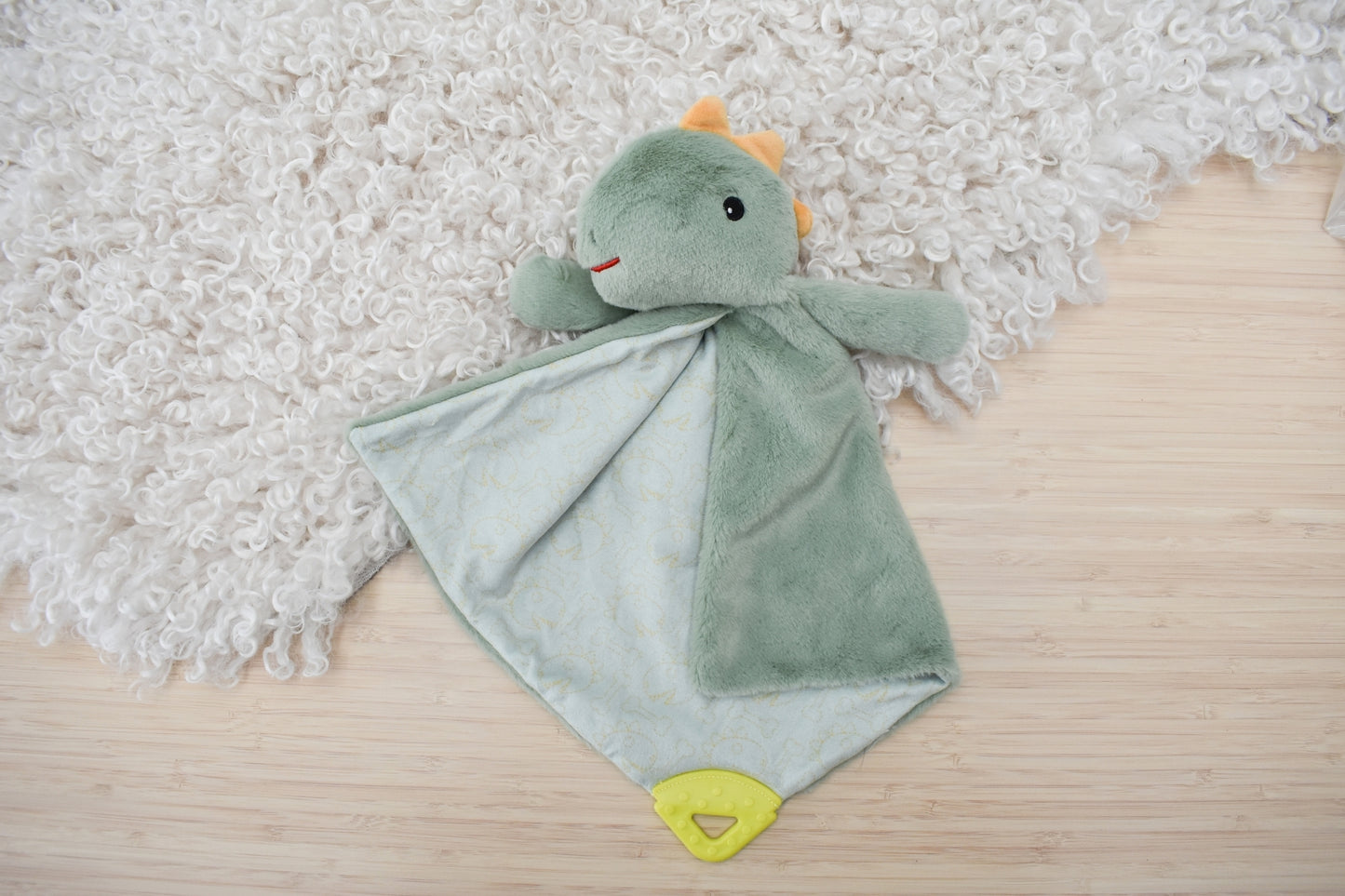 Snuggle Buddy Minty Dinosaur Teether Blanket with soothing teething relief for babies.