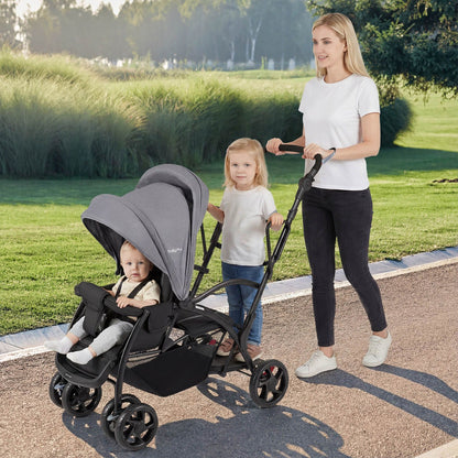 Woman pushing a stroller with two children in a park
