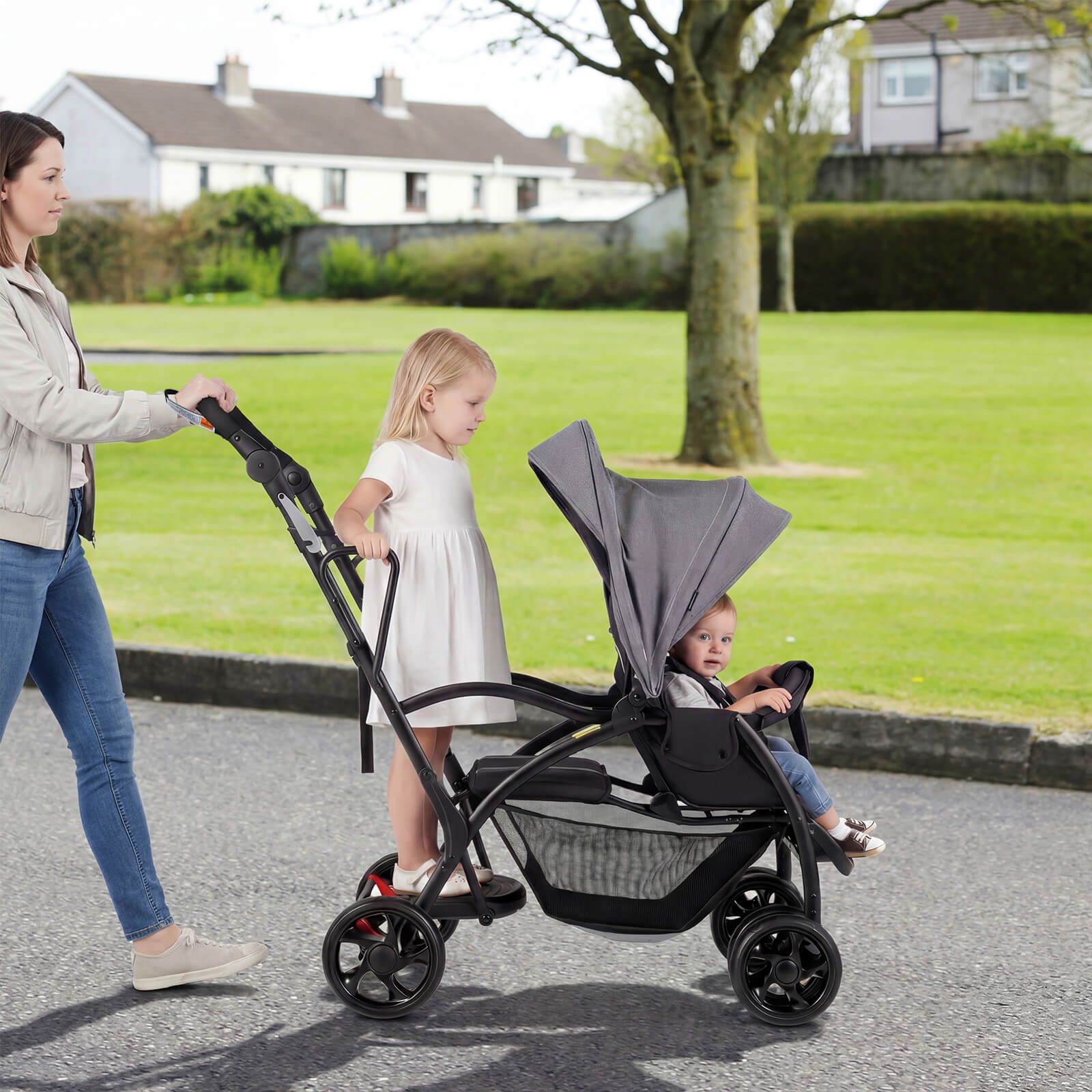 Woman pushing a stroller with two children in a park