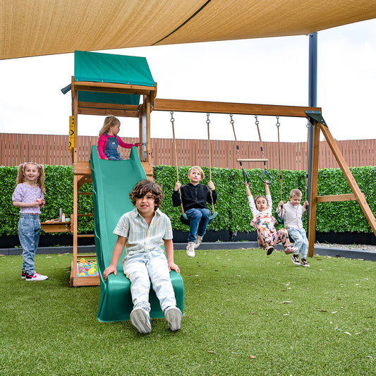 Birmingham playset with green wavy slide and durable timber construction.