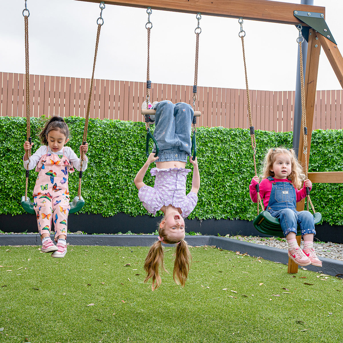 Children playing on belt swings of the Birmingham play centre green