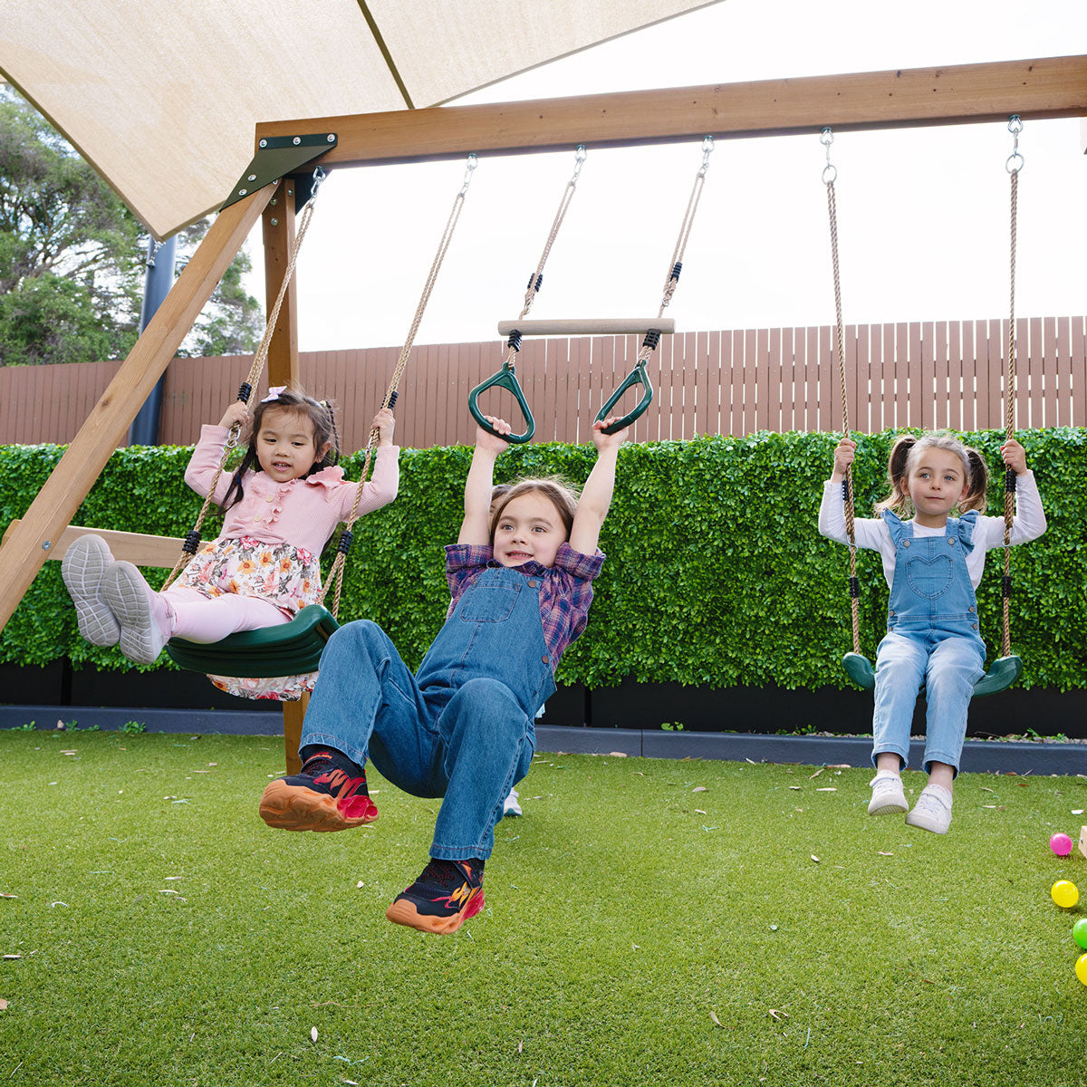 Children enjoying the swings and trapeze bar on Carindale Play Centre