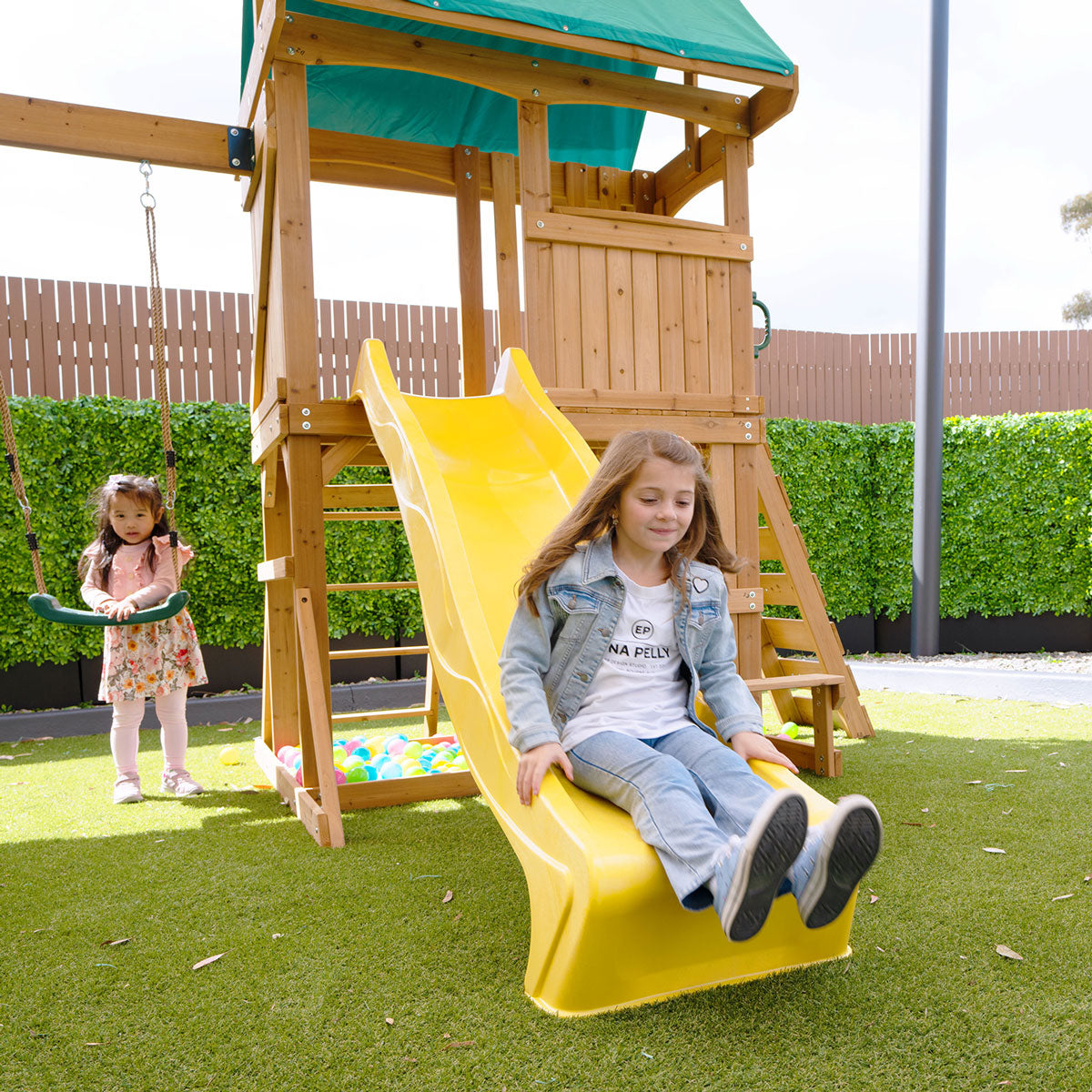 backyard playground featuring swings and a yellow slide for outdoor fun and active play.