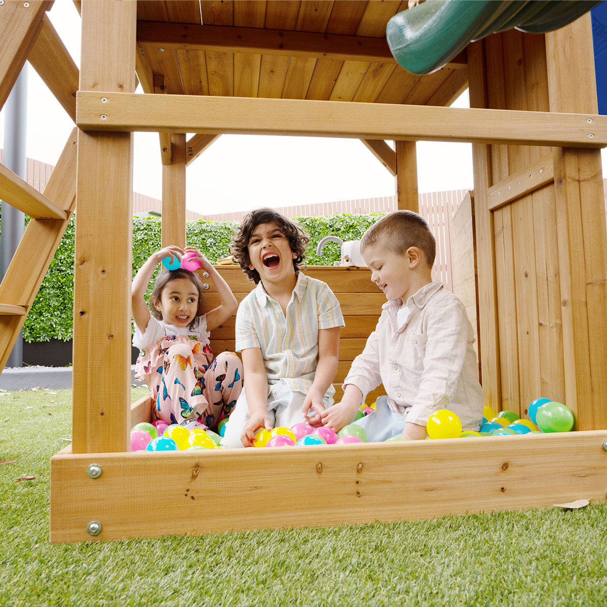 Lifespan Kids Montrose Play Centre with 2.2m Blue Slide, two belt swings, and trapeze bar in a backyard setting