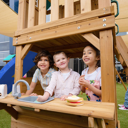 Lower level hideaway of the Montrose Play Centre featuring a door, window, and play kitchen for imaginative play.

