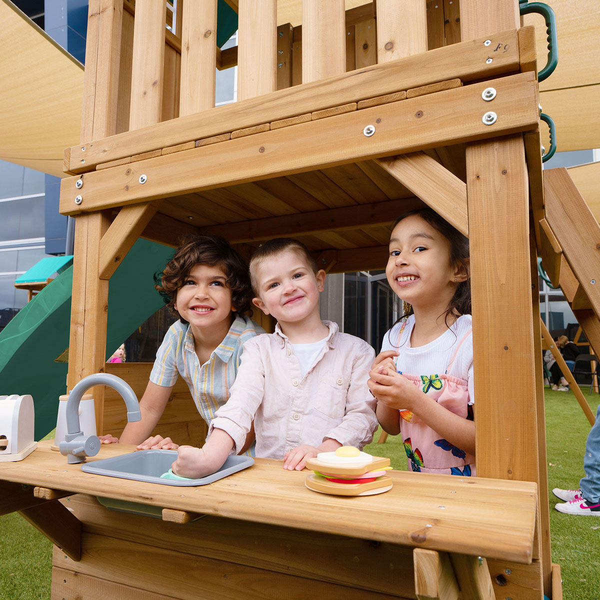 Montrose outdoor play set features a tall green slide and multiple activities for backyard fun and exercise.