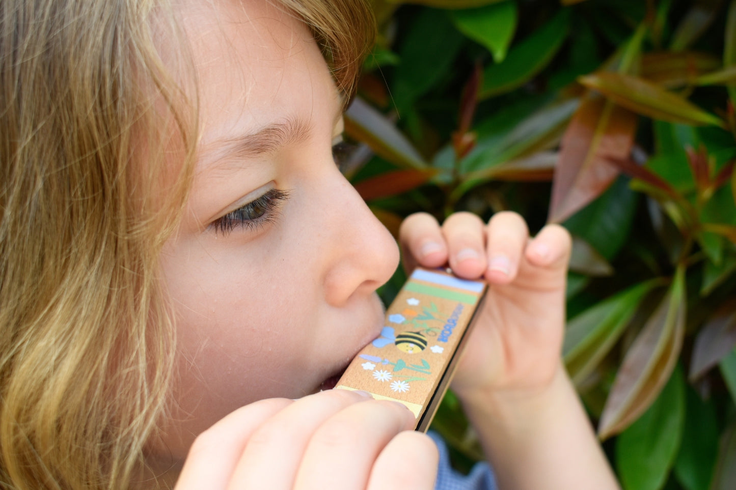 Colorful wooden bee-shaped harmonica toy encourages musical exploration and fine motor skills development through playful