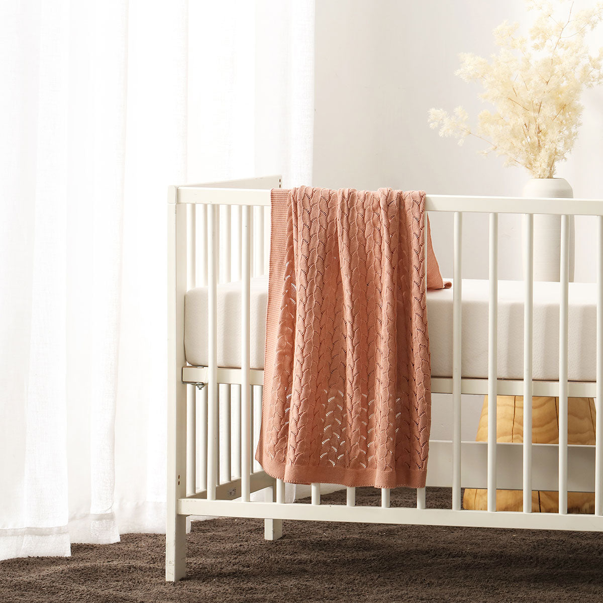 Organic cotton baby blanket in dusty pink, soft and safe for cozy, gentle warmth.