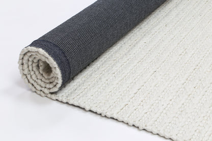White wool blend tribal rug with soft texture, ideal for childrens play or nursery decor.