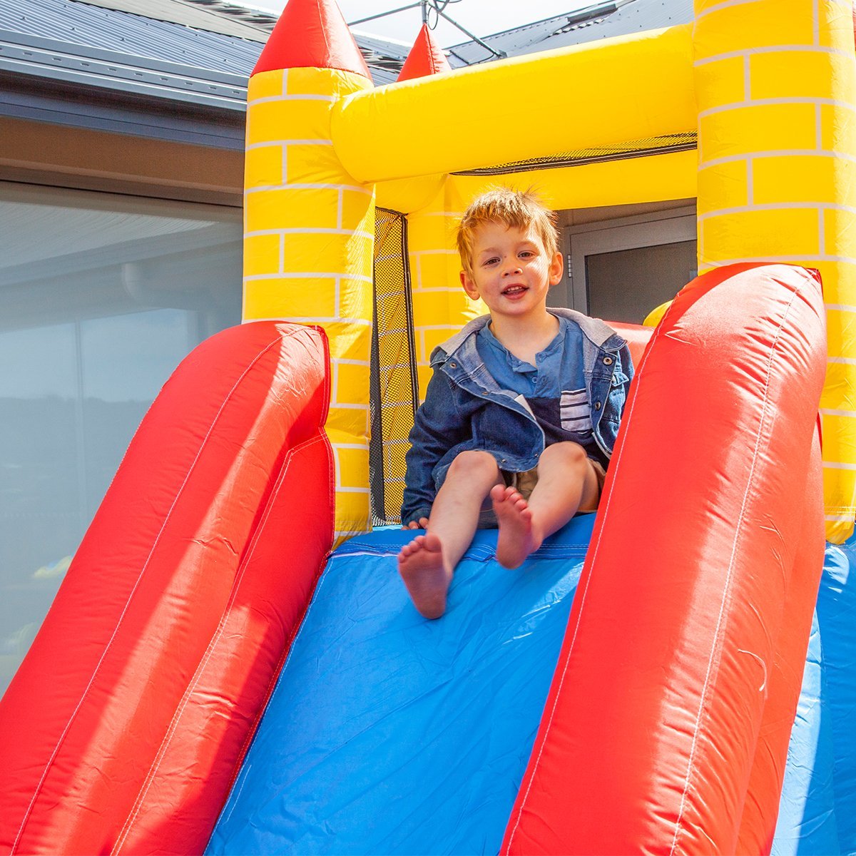 Child playing on slide in jumping castle