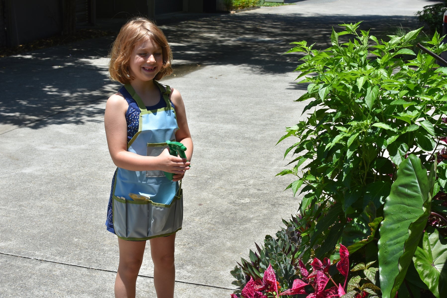 Kids garden tool apron in calming design for young gardeners to carry tools easily.