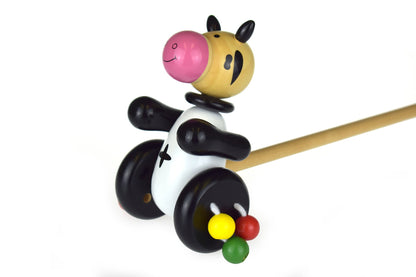 Wooden push along cow toy for interactive play, perfect for toddlers and preschoolers.