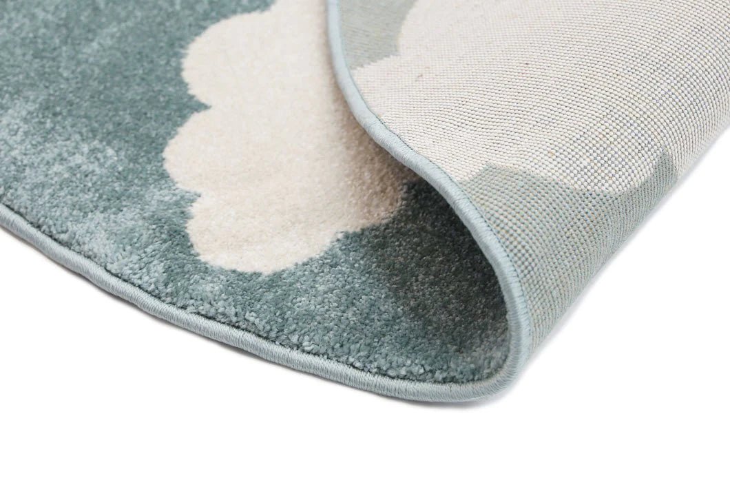 Kids rug with aqua and white clouds design, soft and cozy for playtime.